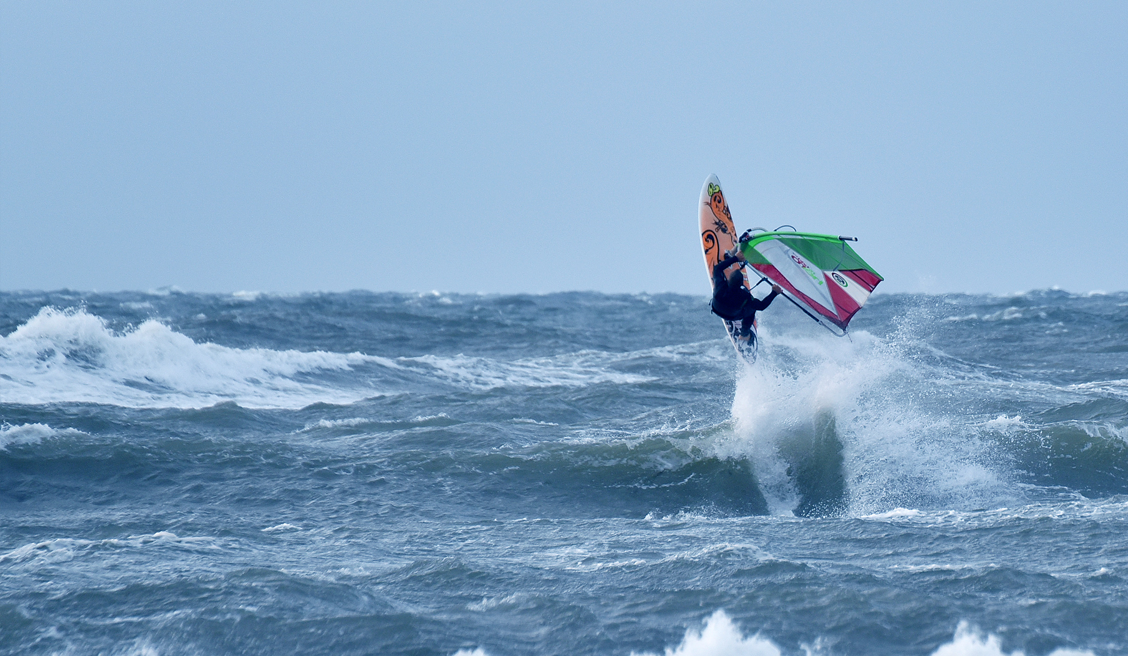 Mann surft bei starkem Wind auf der Ostsee